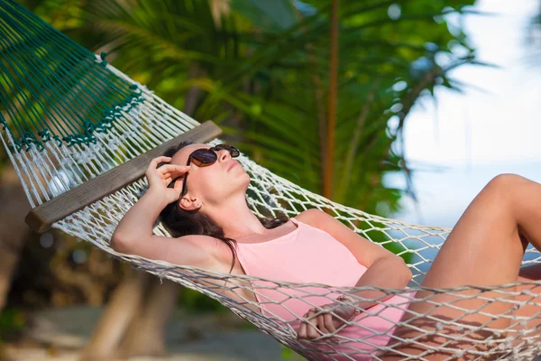Frau im Badeanzug entspannt sich in der Hängematte beim Sonnenbaden im Urlaub — Stockfoto