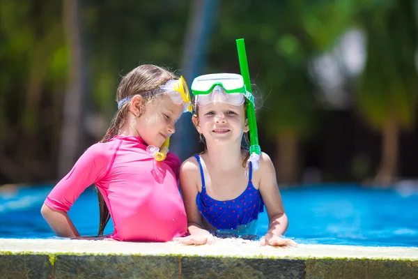 Adorable little girls at mask and goggles in outdoor swimming pool — Stock Photo, Image