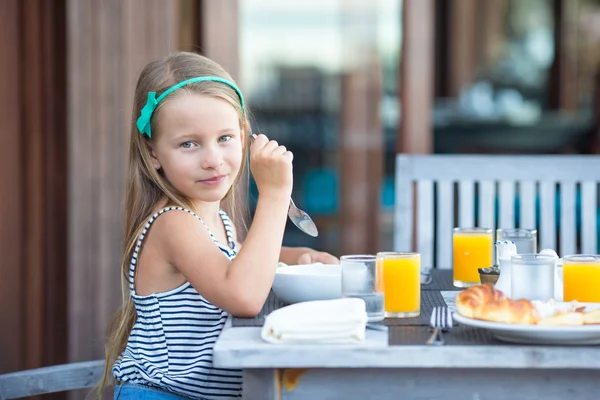 Adorável menina tomando café da manhã no café ao ar livre — Fotografia de Stock