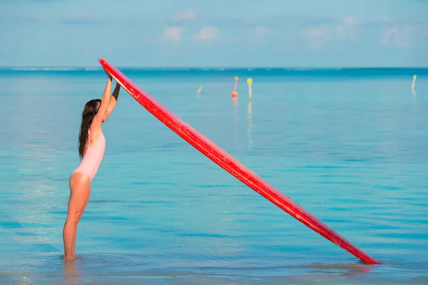 Glücklich schöne Surferin Mädchen am Strand mit ihrem Surfbrett — Stockfoto