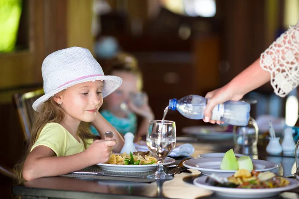 Adorable little girl having dinner at outdoor restaurant — Stock Photo, Image