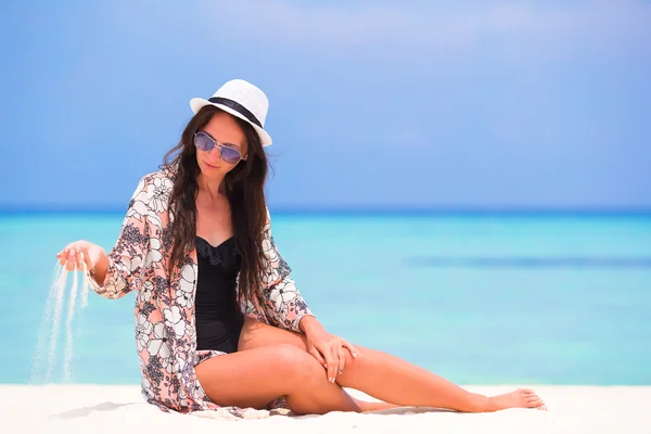 Retrato de una joven arrojando arena a la playa durante las vacaciones de verano — Foto de Stock