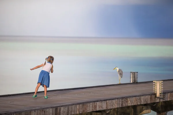 Schattig gelukkig meisje met reiger op strandvakantie — Stockfoto