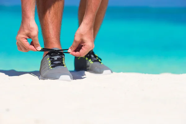 Joven corredor masculino preparándose para comenzar en la playa blanca — Foto de Stock