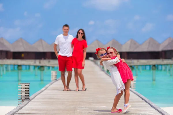 Felice bella famiglia sul molo di legno durante le vacanze estive al resort di lusso — Foto Stock