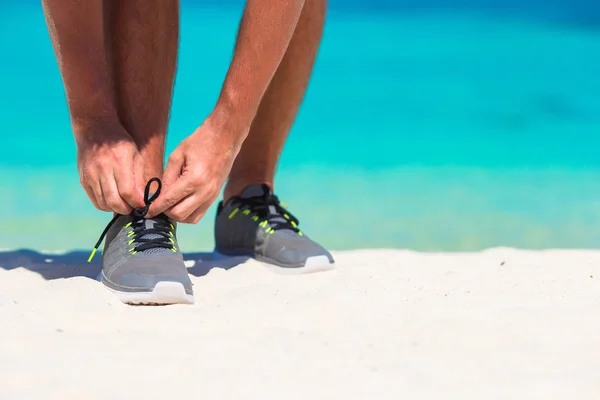 Joven corredor masculino preparándose para comenzar en la playa blanca — Foto de Stock