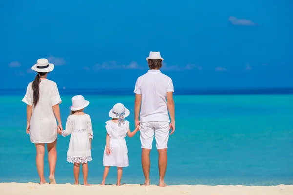 Vista trasera de la hermosa familia en una playa durante las vacaciones de verano — Foto de Stock