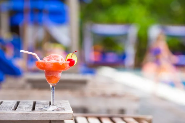 Tasty cocktail on wooden table near swimming pool — Stock Photo, Image