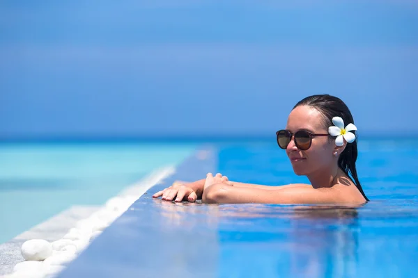 Jonge mooie vrouw genieten van zomervakantie in luxe zwembad — Stockfoto