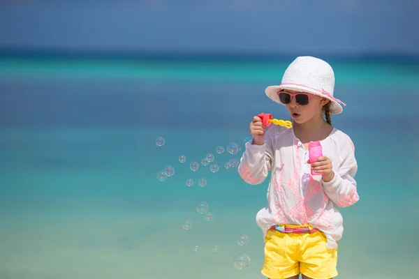 Adorável menina soprando bolhas de sabão na praia — Fotografia de Stock