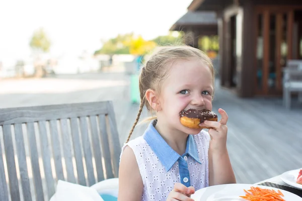 Adorable niña tomando el desayuno en la cafetería al aire libre —  Fotos de Stock