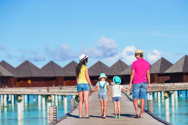 Vue arrière de la belle famille sur jetée en bois pendant les vacances d'été à la station de luxe — Photo