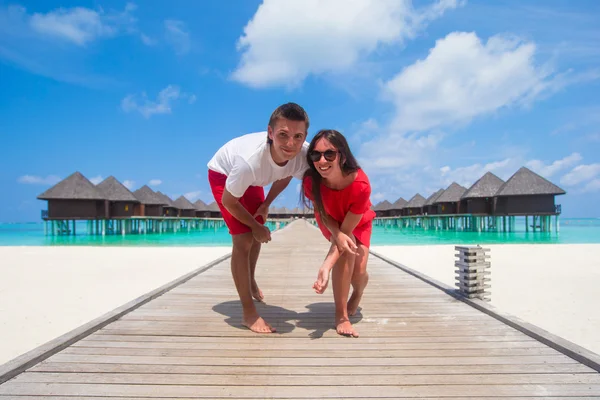Young couple on tropical beach jetty at perfect island — Stock Photo, Image