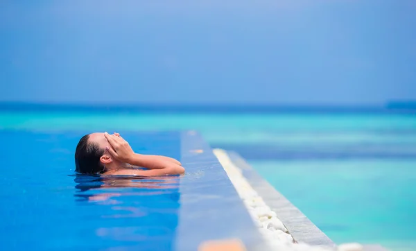 Mujer joven disfrutando del agua y el sol en la piscina al aire libre . —  Fotos de Stock