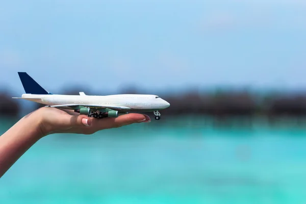 Pequeño avión de juguete blanco sobre fondo de mar turquesa — Foto de Stock