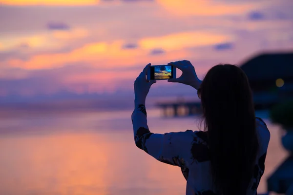 Kobieta robi zdjęcie na jej telefon piękny zachód słońca — Zdjęcie stockowe