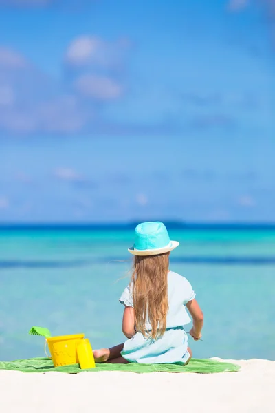 Nettes kleines Mädchen mit Hut am Strand während der Sommerferien — Stockfoto