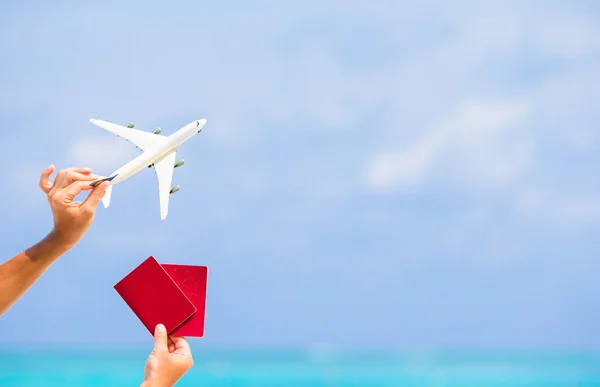 Крупный план паспортов и белый самолет фоне моря — стоковое фото