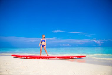 Küçük sevimli kız pratik sörf pozisyon Beach