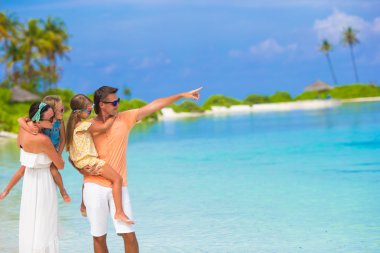 Yaz tatili sırasında beyaz plaj üzerinde mutlu aile