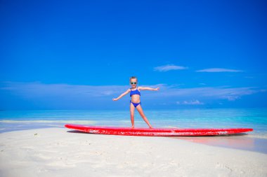 Küçük sevimli kız pratik sörf pozisyon Beach