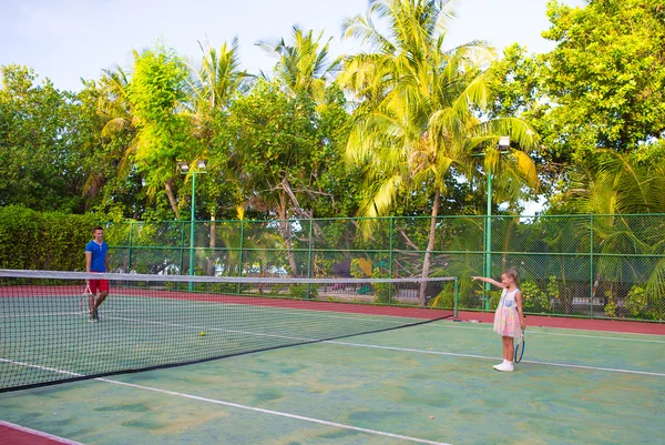 Little girl playing tennis with her dad on the court — Stock Photo, Image