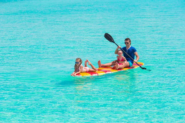 Little girls and young dad on surfboard during summer vacation — Stock Photo, Image