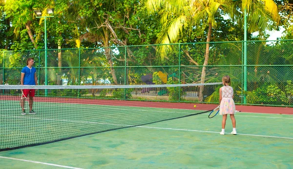 Küçük kız babası Tenis oynarken sahada — Stok fotoğraf