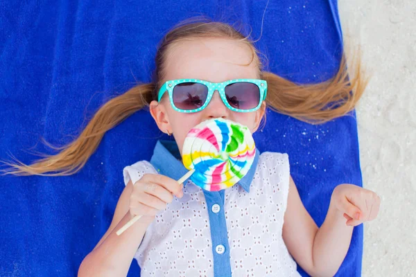 De cerca adorable niña con piruleta en la playa tropical — Foto de Stock