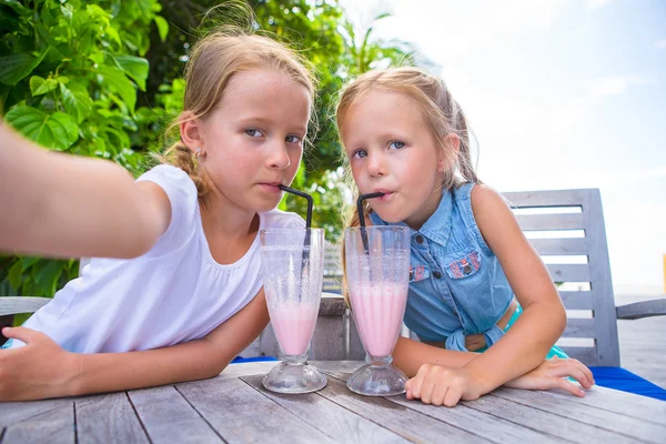 Little girls taking selfie and drinking tasty cocktails at tropical resort — Stock Photo, Image