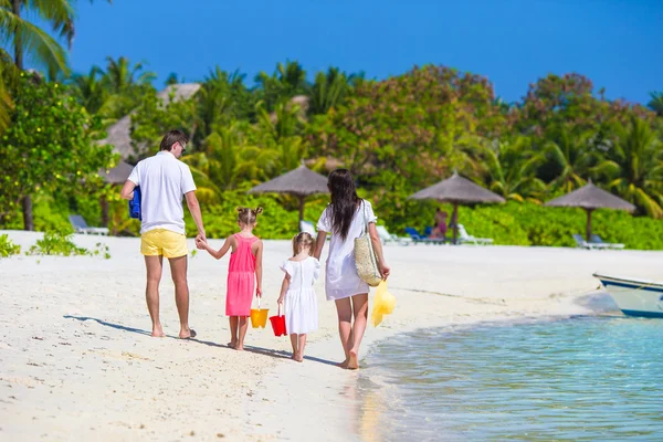 Vista trasera de la familia joven en la playa durante las vacaciones de verano —  Fotos de Stock