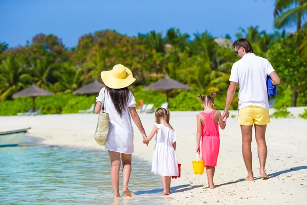 Yaz tatilinde beyaz plajda genç bir aile. — Stok fotoğraf