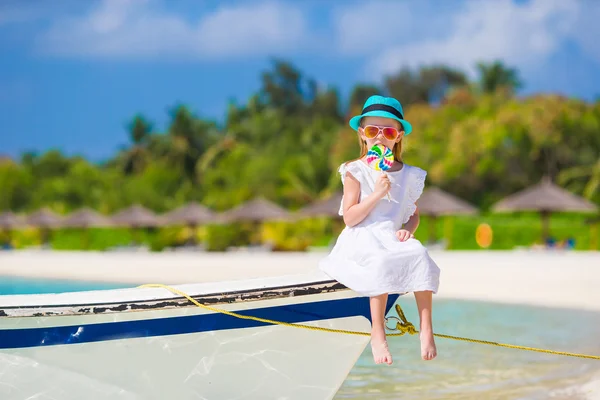 Menina adorável com pirulito na praia tropical — Fotografia de Stock