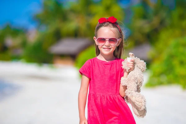 Adorable little girl playing with toy during beach vacation — Stock Photo, Image