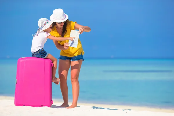 Madre e figlioletta con bagagli e mappa sulla spiaggia — Foto Stock