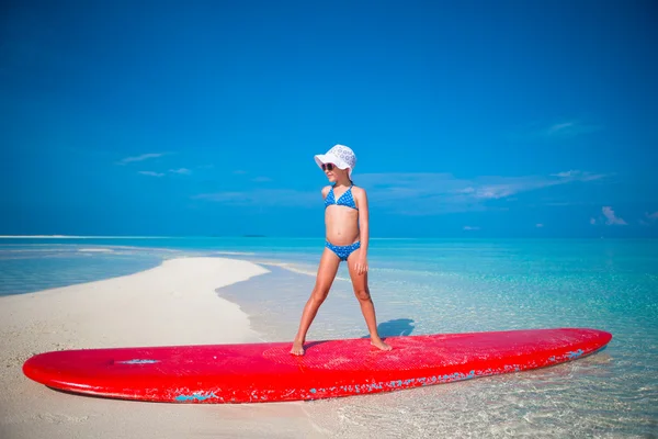 Poco adorable chica practicar surf posición en la playa —  Fotos de Stock