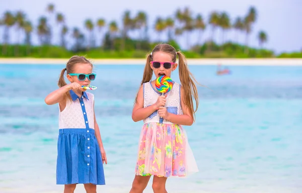 Adorables niñas con piruleta en la playa tropical —  Fotos de Stock