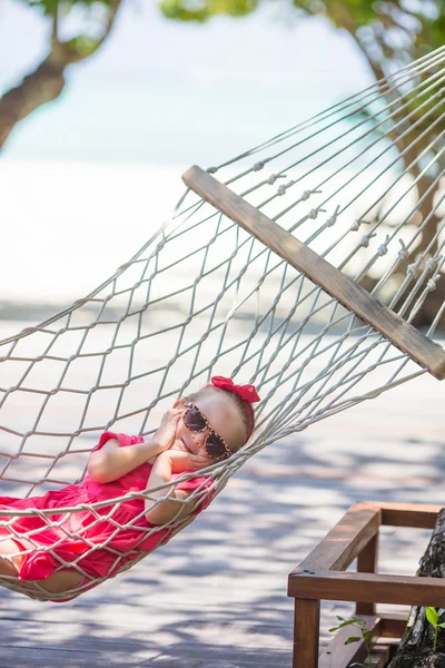 Rozkošná holčička na tropickou dovolenou v houpací síti — Stock fotografie