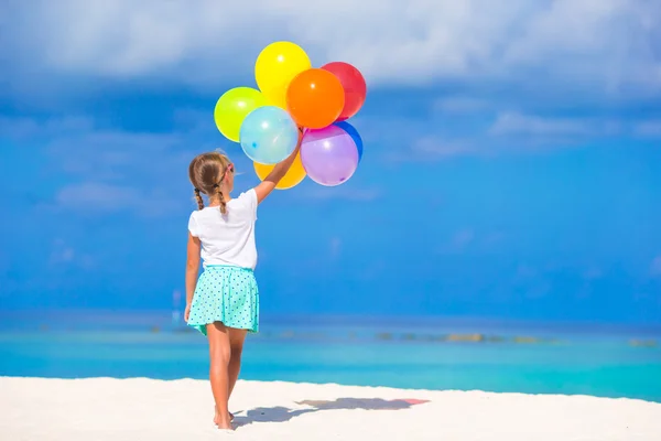 Adorable niña jugando con globos en la playa —  Fotos de Stock