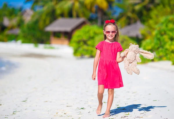 Adorable little girl playing with toy during beach vacation — Stock Photo, Image
