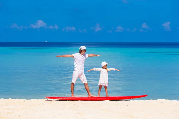 Père avec petite fille à la plage pratiquant la position de surf — Photo