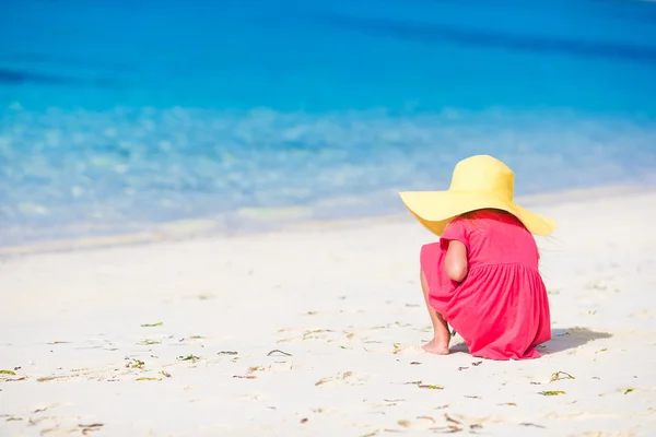 Adorable little girl drawing on white sand at the beach — Stock Photo, Image