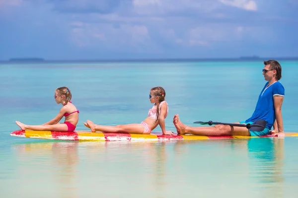 Kleine Mädchen und junger Papa auf dem Surfbrett in den Sommerferien — Stockfoto