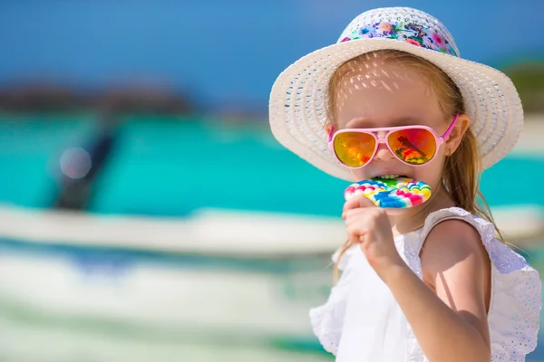 Lolipop tropikal plaj ile sevimli küçük kız — Stok fotoğraf