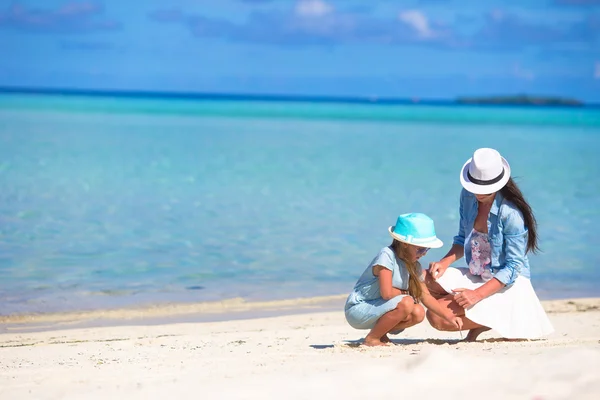 Mère et bébé fille dessin sur la plage de sable — Photo