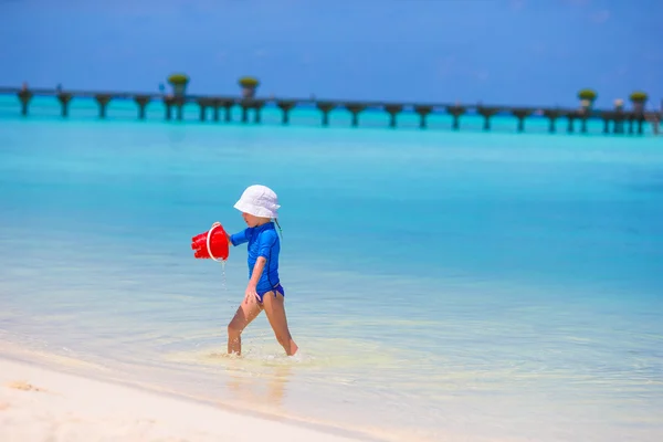 Adorable little girl playing with beach toys during tropical vacation — Stock Photo, Image