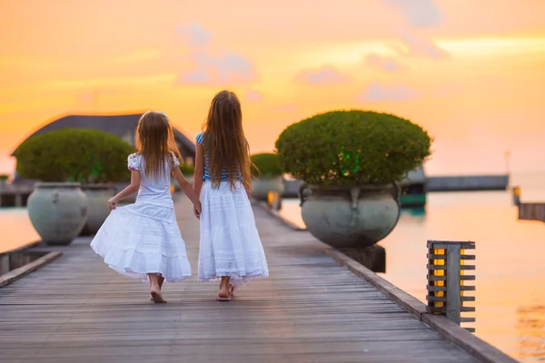 Entzückende kleine Mädchen bei Sonnenuntergang auf Holzsteg — Stockfoto