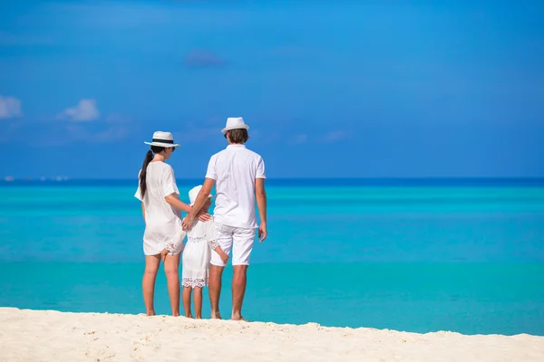 Yaz tatilinde beyaz plajda genç bir aile. — Stok fotoğraf