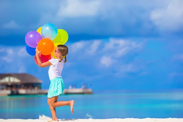 Χαριτωμένο μικρό κορίτσι παίζει με μπαλόνια στην παραλία — Φωτογραφία Αρχείου