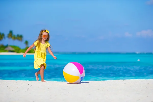 Маленькая очаровательная девочка играет на пляже с мячом — стоковое фото